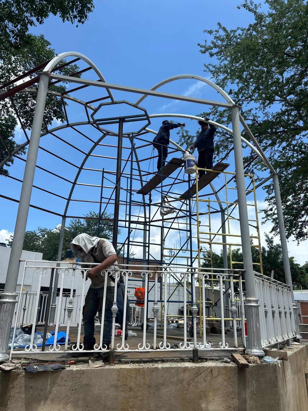 Soldadores trabajando en lo alto del esqueleto de acero de la cúpula